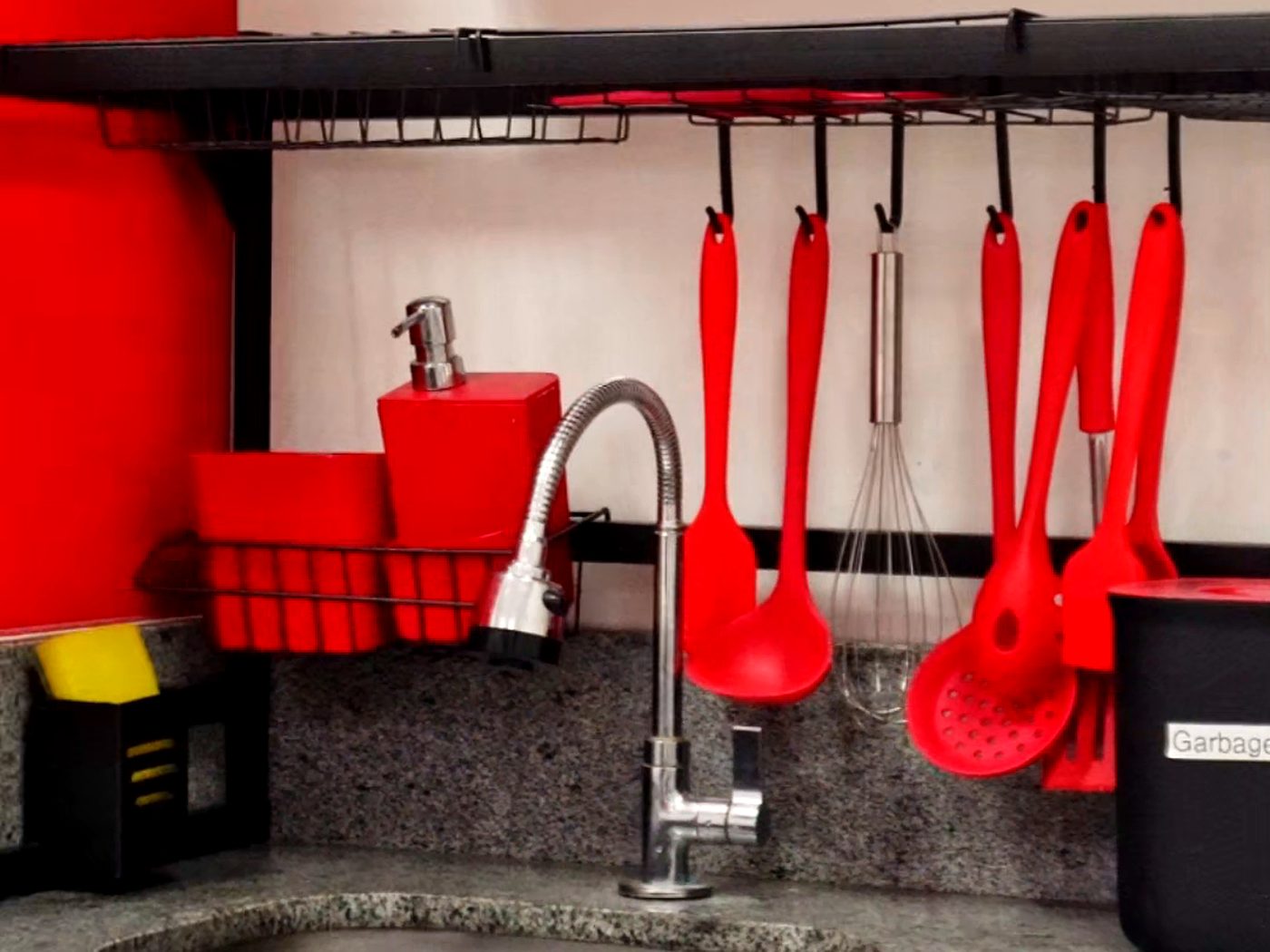 Cozinha experimental da unidade, com utensílios vermelhos e bancada de granito
