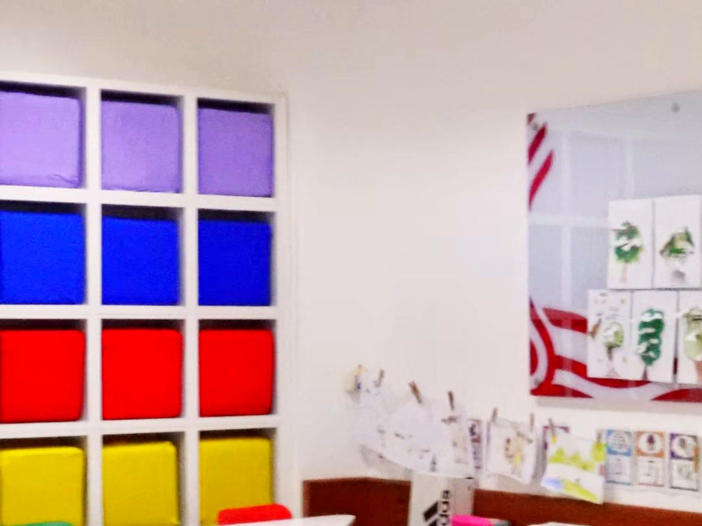 Sala das turmas infantis com painéis coloridos e mesas baixas